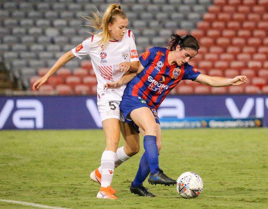 HIGH HOPES: Jets winger Lauren Allan holds Adelaide defender Charlotte Grant off the ball at McDonald Jones Stadium in their W-League clash last season. Picture: Max Mason-Hubers