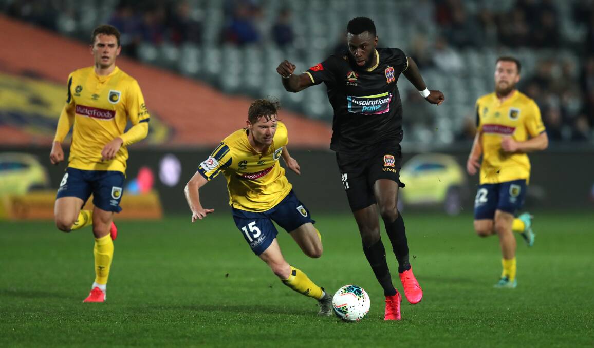 ON THE FLY: Bernie Ibini breaks free from the Mariners defenders in the Jets' nil-all draw in Gosford on Friday night. Picture: Getty Images.