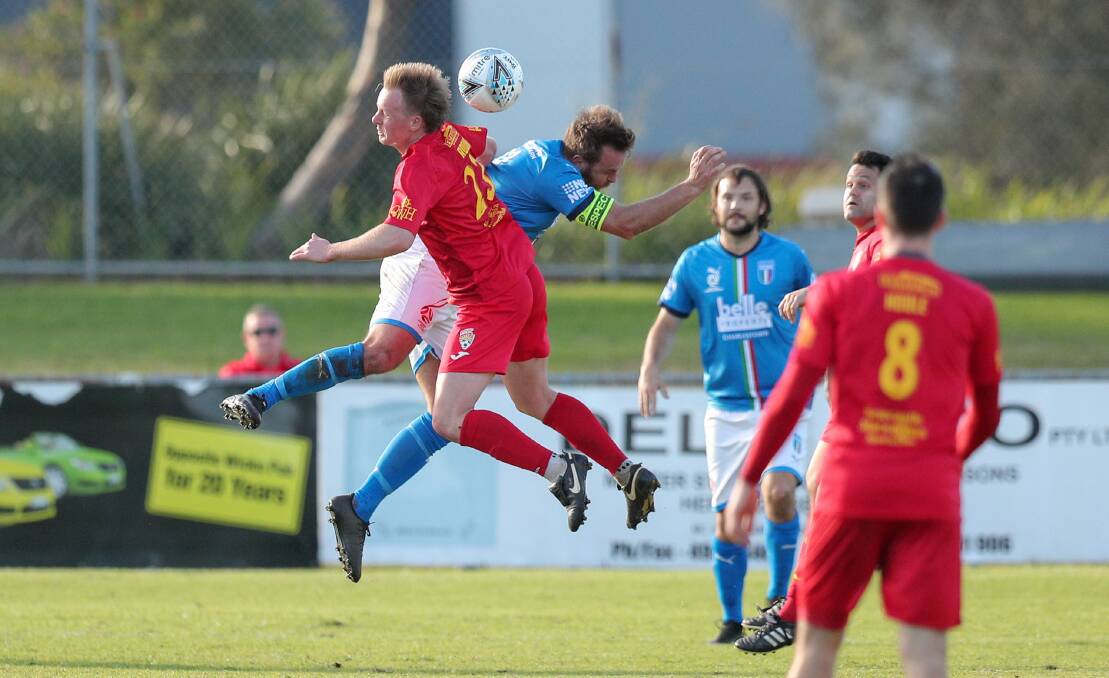 FLYING START: Mitch Rooke, in the red, contests a header with Charlestown's Rene Ferguson on Sunday in Broadmeadow's 3-1 win at Magic Park. Picture: Max Mason-Hubers