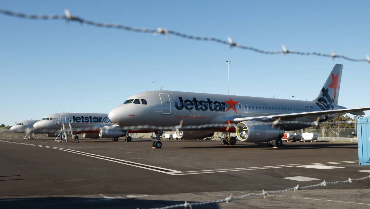 GOING NOWHERE: Jetstar aircraft parked on the tarmac at Williamtown. Parent company Qantas has grounded 100 planes for a year. 