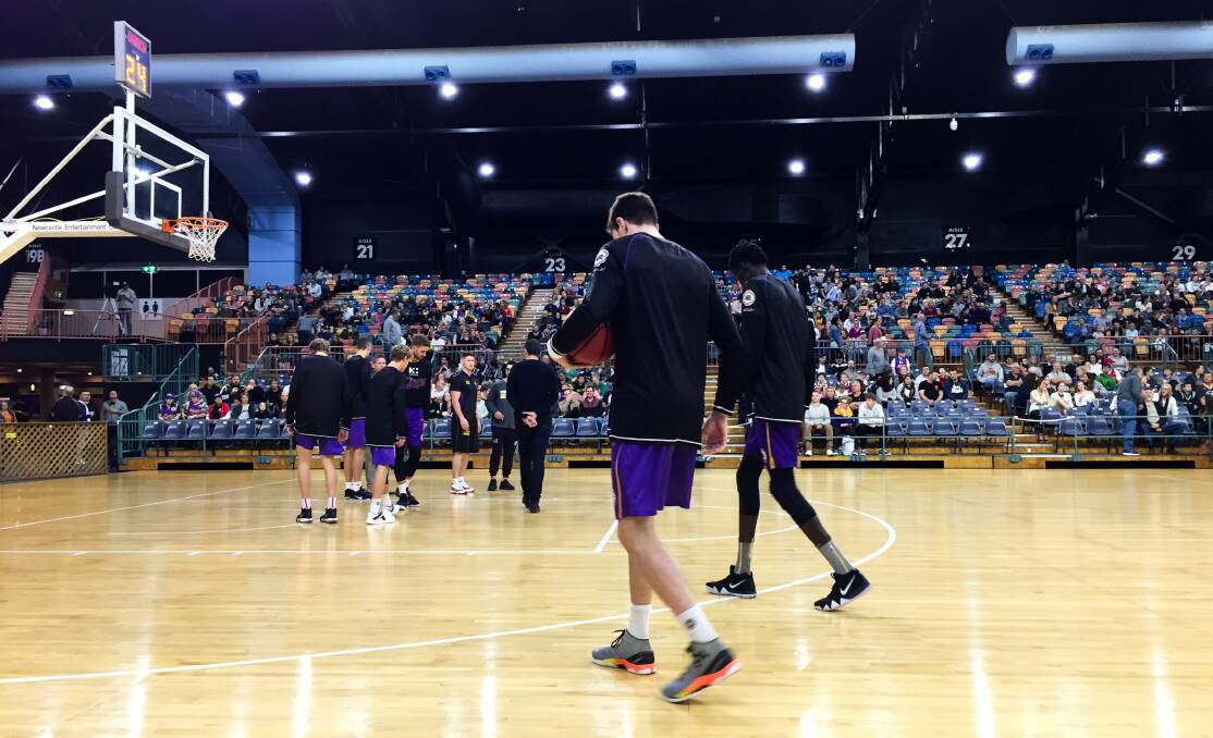 Sydney Kings players check the surface of the Newcastle Entertainment Centre court on Saturday night. Picture: Jonathan Carroll