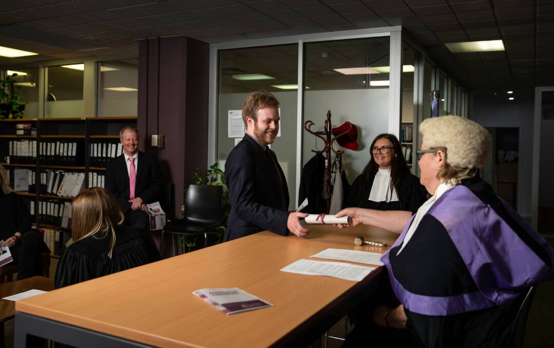 Celebrate: Principal Catherine Henry presents solicitor Nick Audet with a replica certificate. Picture: Marina Neil