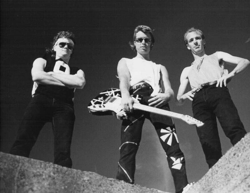Greg Bryce, centre, with his bandmates during the 1980s in rock group DV8. Picture: Supplied