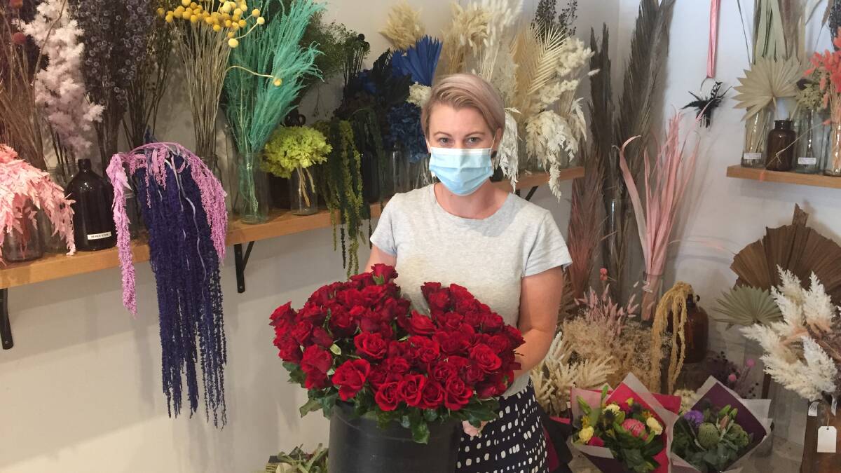 IN BLOOM: Three Bloom's owner Bec McDougall with some of the many roses she is trying to sell before the business temporarily closes today. Picture: KLAUS NANNESTAD
