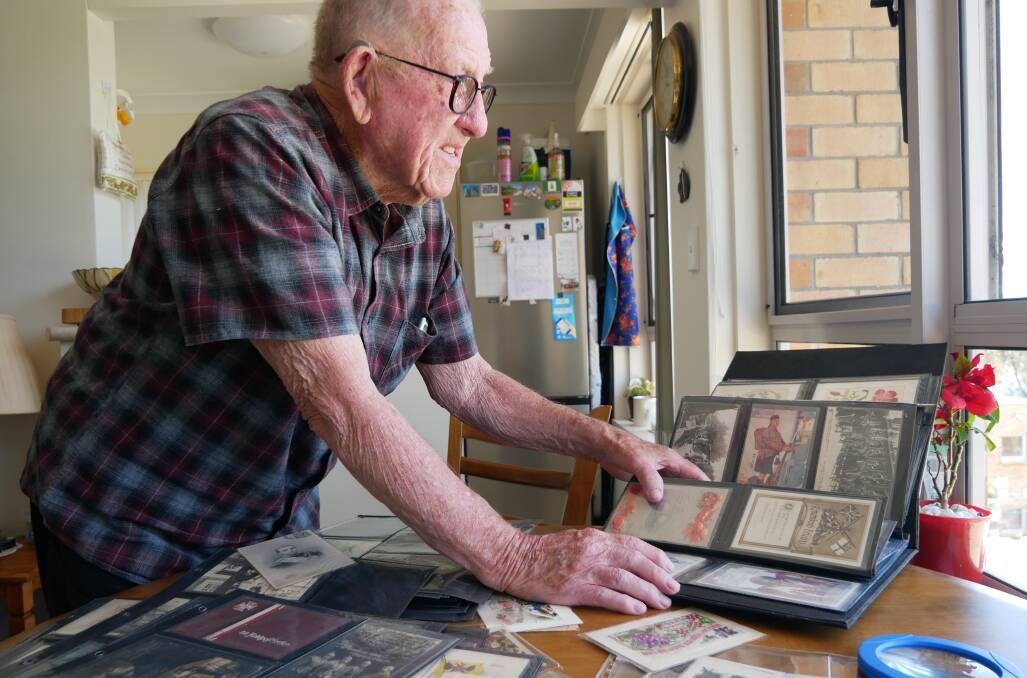 William looks through his collection of postcards, sorted into albums. Picture by Ellouise Bailey 