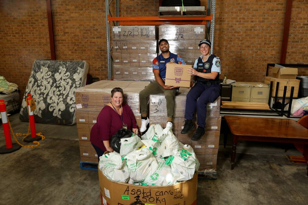 HIGH DEMAND: Survivors R Us founder, Maria Martin, with Lake Macquarie Aboriginal Community Liaison Officer, Ray Fuller, and Senior Constable Elke Watt. Survivors R Us have pushed out 3,000 food relief hampers in the past three months. Picture: Jonathan Carroll.