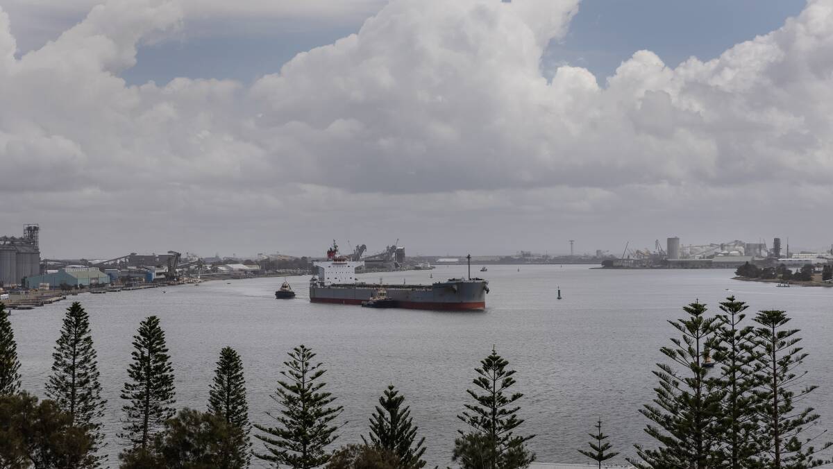 A coal ship being guided by tug boats in Newcastle Harbour. Picture by Marina Neil.