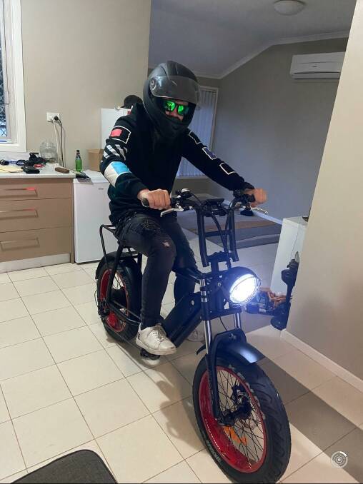 Luke Rossington on the e-bike which was stolen from his home at Cardiff.