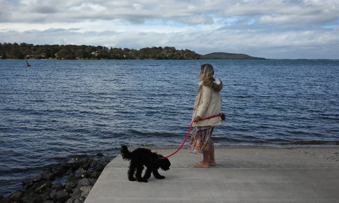 LOCKED OUT: Coralie Ryder, with her support dog, Shadwick, at Fennell Bay, hopes she can self-quarantine at home upon return to Queensland. Picture: Simone De Peak