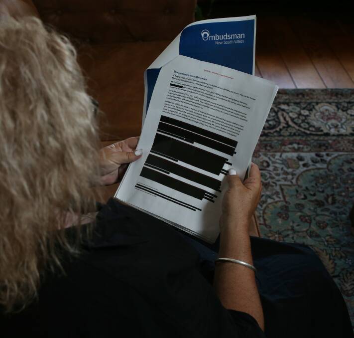 Rebecca Connor at her home in Stockton looks over the heavily redacted contents of a NSW Ombudsman's report which details a litany of failures at the Maitland mining titles office. Picture by Simone De Peak 