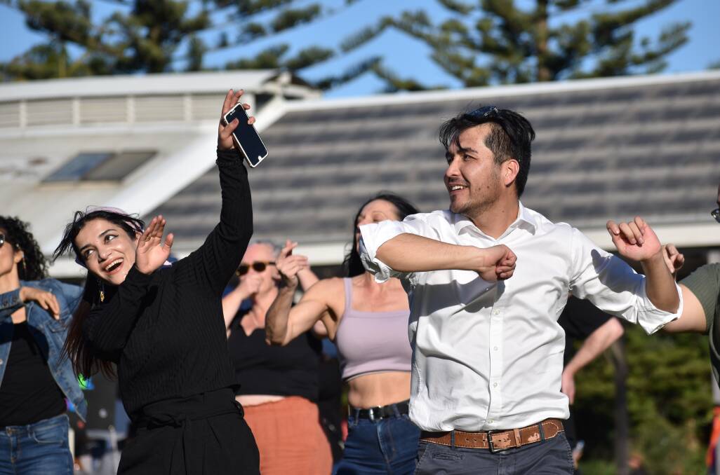Azim (white shirt), dancing to Cuban music on Saturday, is a member of the Afghan Hazara community in Newcastle. Picture: Ethan Hamilton