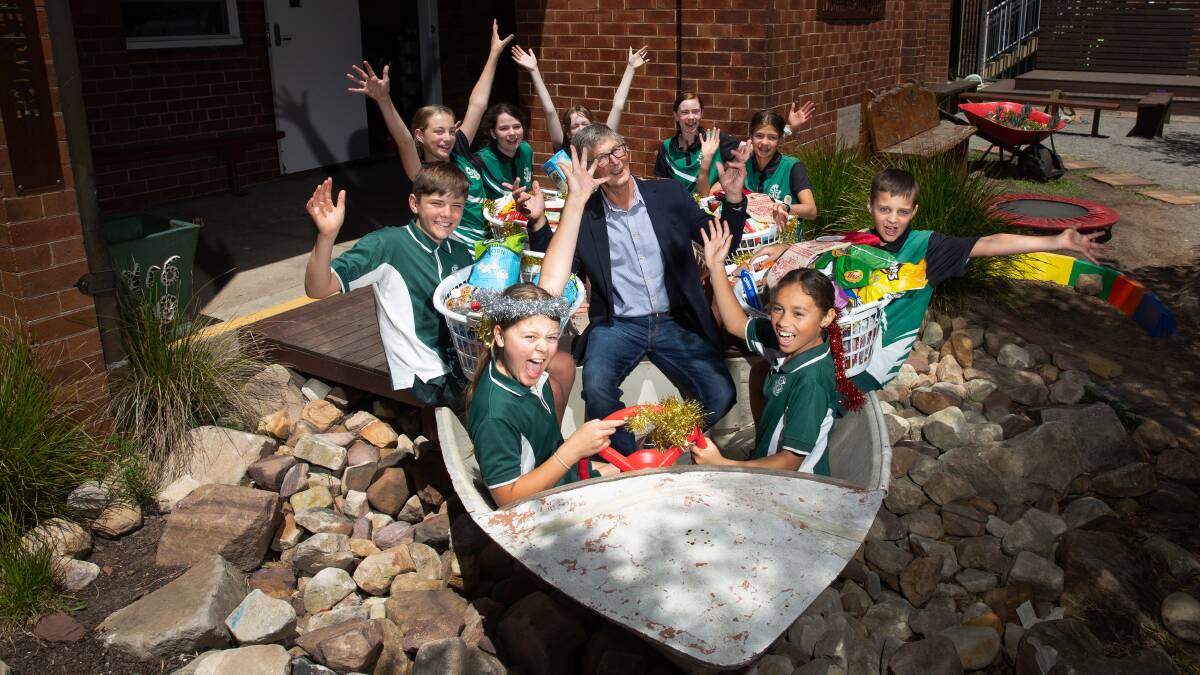 Spirit of giving: St Vincent de Paul member Tim Howes with students from Corpus Christi Primary School who gathered food for the Christmas appeal. Picture: Marina Neil. Picture: Marina Neil.