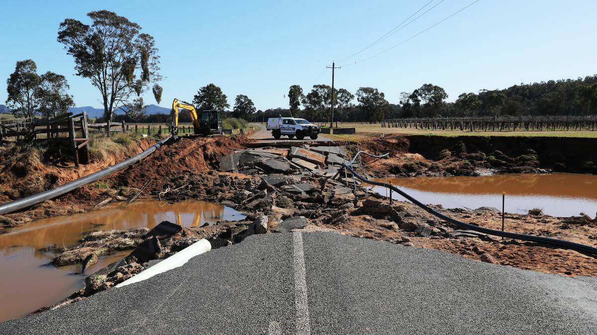 Three weeks after a swollen Wollombi Brook ripped through Broke, the village still resembles a disaster zone. Flood-damaged furniture, clothing and other household items are piled up on the street with a section of Broke Road completely destroyed. Pictures: Peter Lorimer and Simone De Peak
