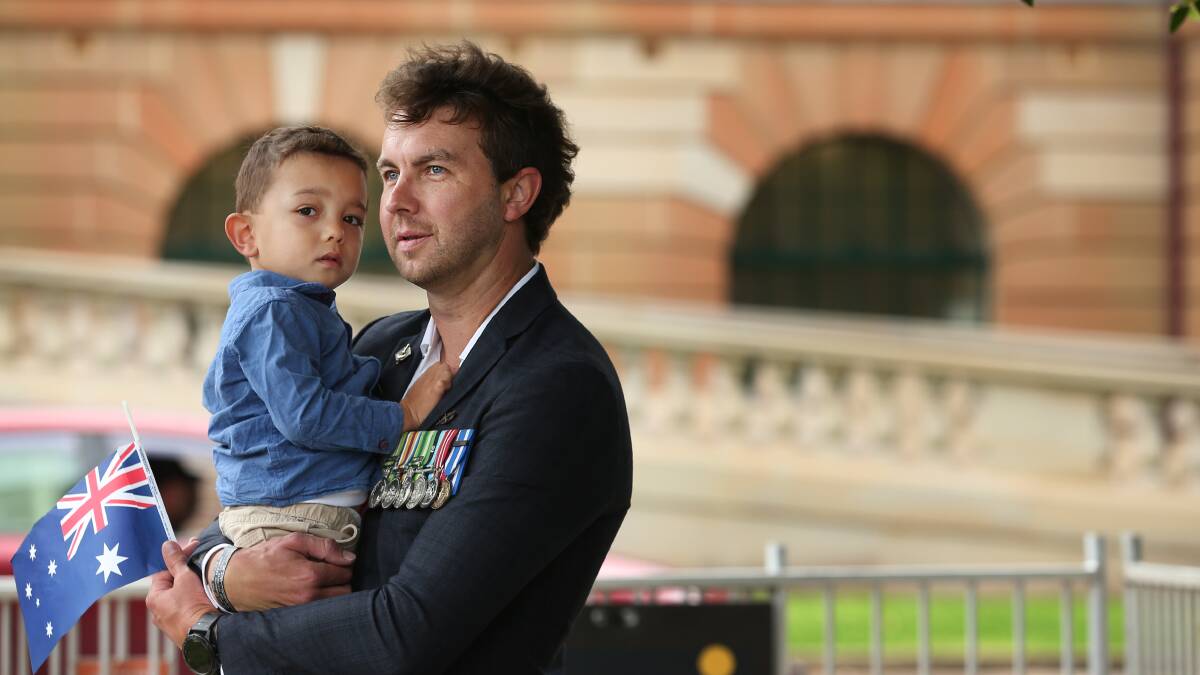 Proud: Scott Jones of Newcastle with his son Chase at Remembrance Day in Civic Park. Picture: Simone De Peak