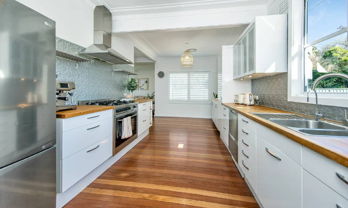 The kitchen features timber benchtops, pressed metal splashback and high-end appliances. Picture supplied