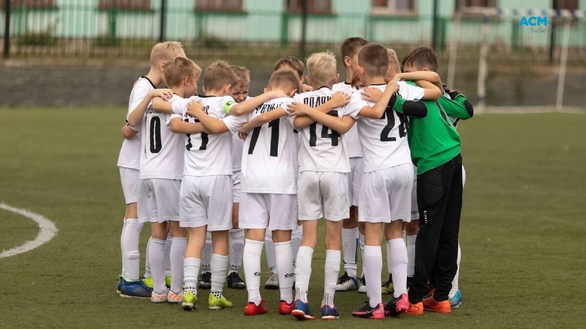 A kids soccer team huddle together before the match. Picture via Canva
