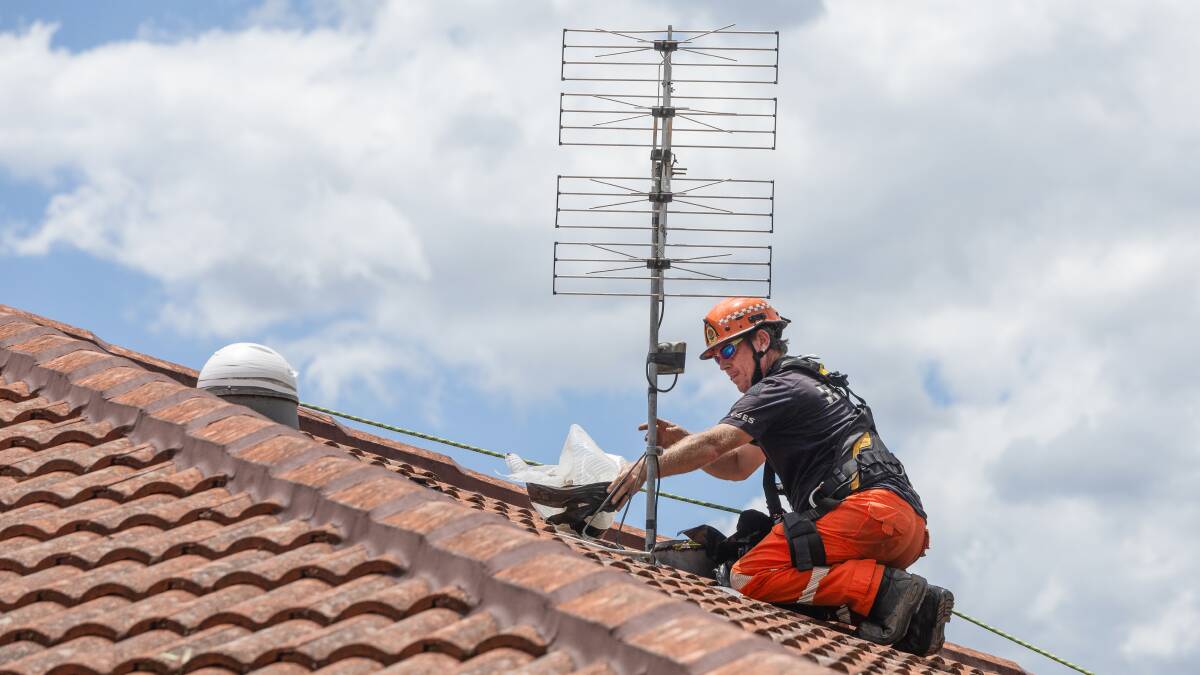 A Maitland SES volunteers fixes a sky light in Rutherford earlier this week. Picture by Marina Neil.