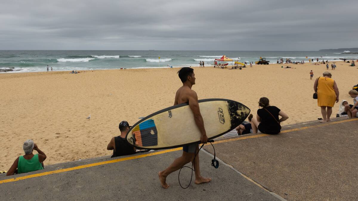 Swimmers and surfers took to the beach despite cold weather. Picture by Jonathan Carroll