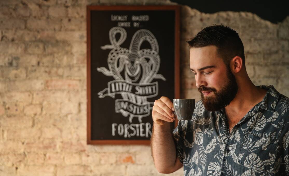 Couldn't be happier: Barista Ricky Reece of Wil & Sons on Darby Street in Cooks Hill with a brew from Little Street Roasters. Picture: Marina Neil