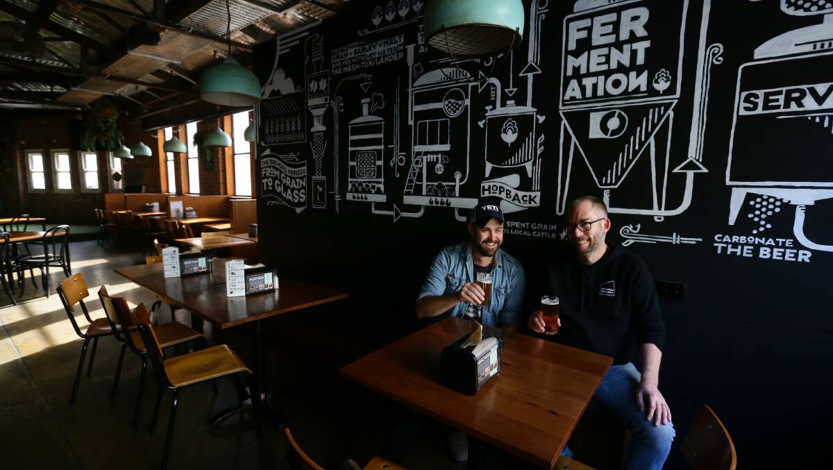 Cheers: Beverages writer Daniel Honan and Shawn Sherlock celebrate a day of hard labour at Foghorn Brewhouse on King Street, Newcastle. Picture: Jonathan Carroll