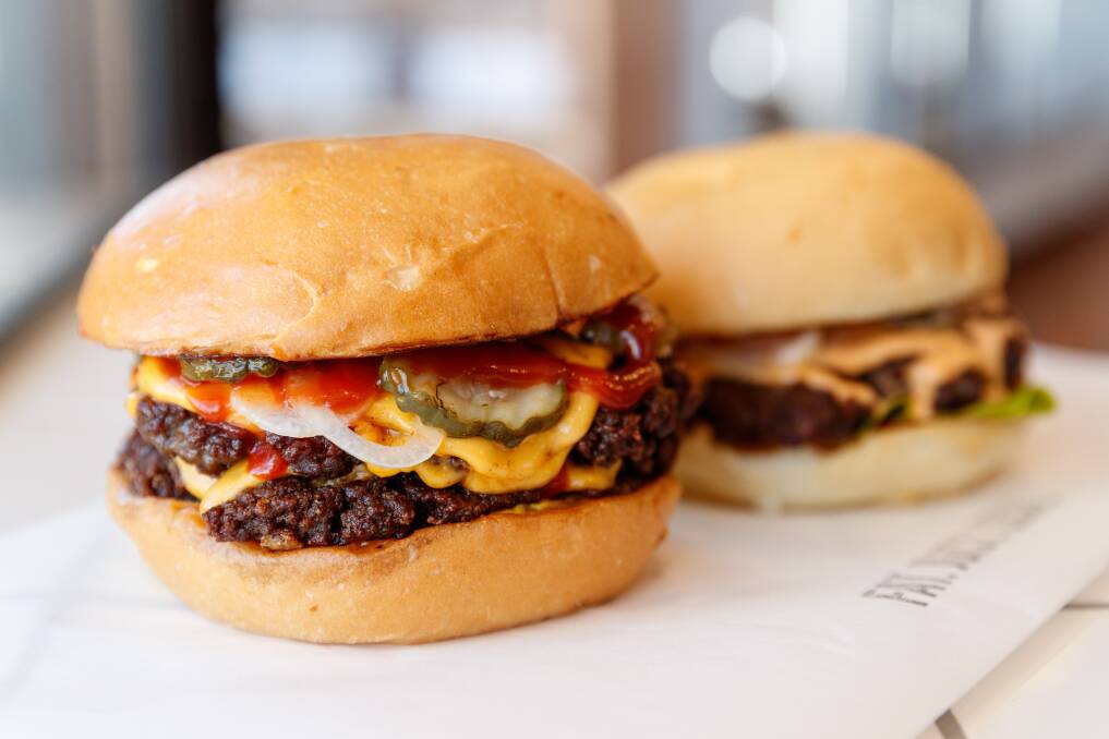 STACKED: Burgers By HMC's double dry aged cheese burger and their classic hamburger. Pictures: Max Mason-Hubers