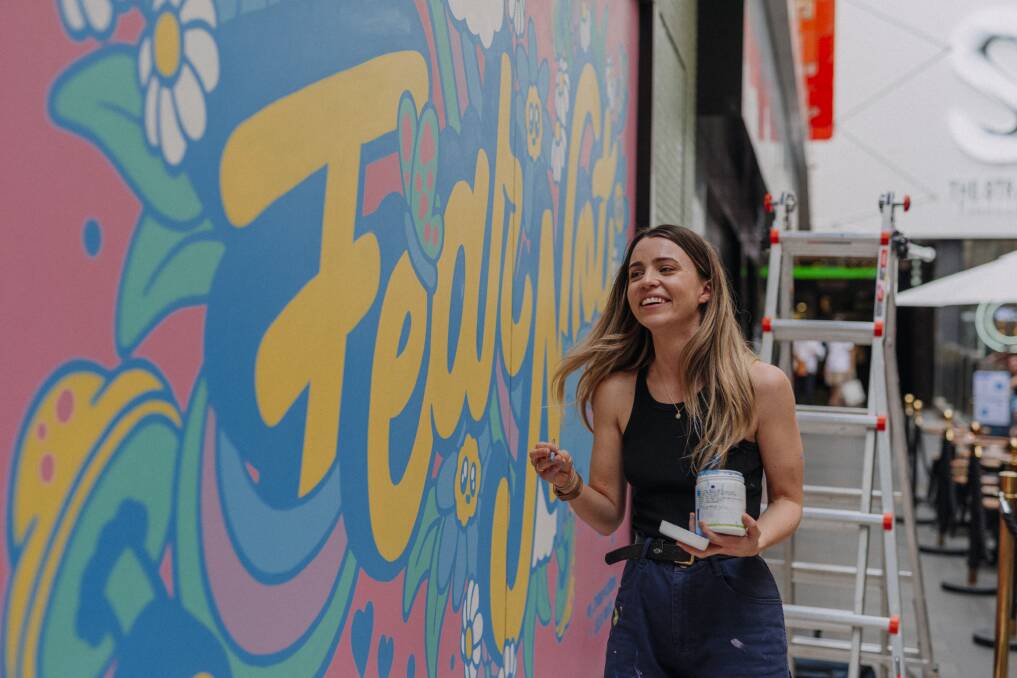 Fun and bold: Ellen Porteus working on a mural at the Strand in Melbourne. Picture: Brent Edwards