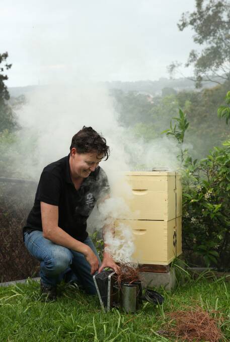 Naturally: Kelly Lees from Urban Hum prepares a bee smoker before inspecting a beehive. The smoke has a calming effect on the bees. Picture: Simone De Peak