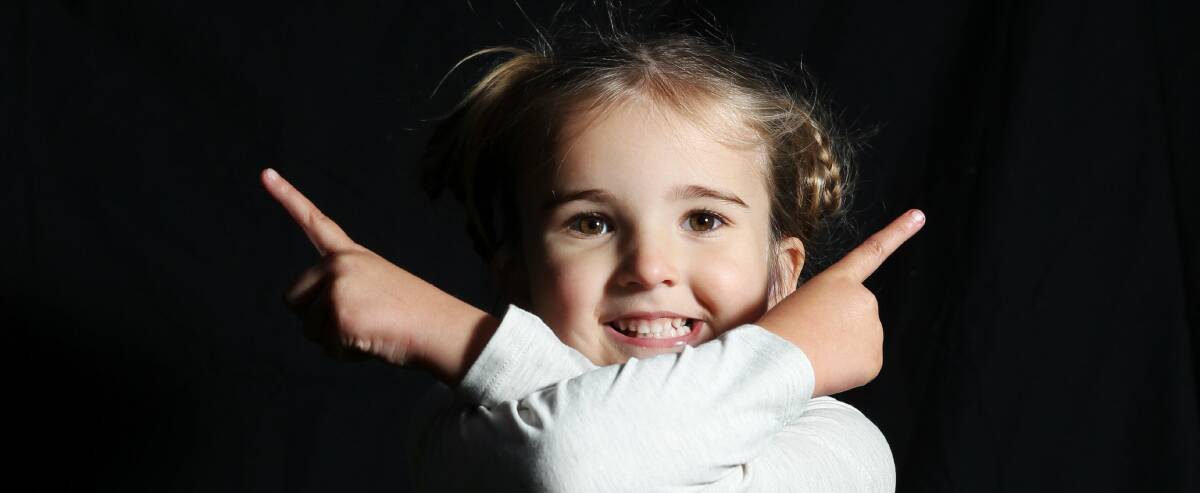Both ways: Abbi Keating, 4, has a Cochlear implant and is learning Auslan sign language. Picture: Max Mason-Hubers