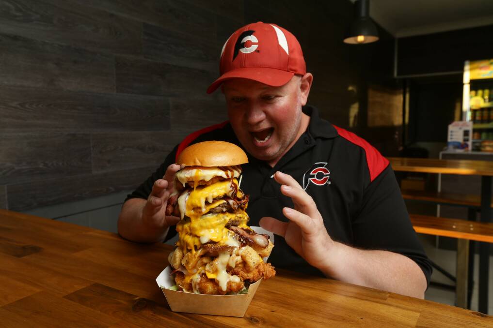 Champion: Competitive food eater Jamie Miller eyes a massive burger at Eight Bulls restaurant in Hamilton. Picture: Jonathan Carroll