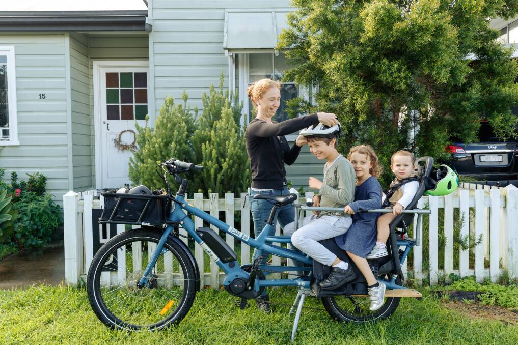 New era: Facing page, Oceane Campbell and her children Dominique, Gabrielle and Emmeline on the family e-bike at Maryville. Picture: Max Mason-Hubers