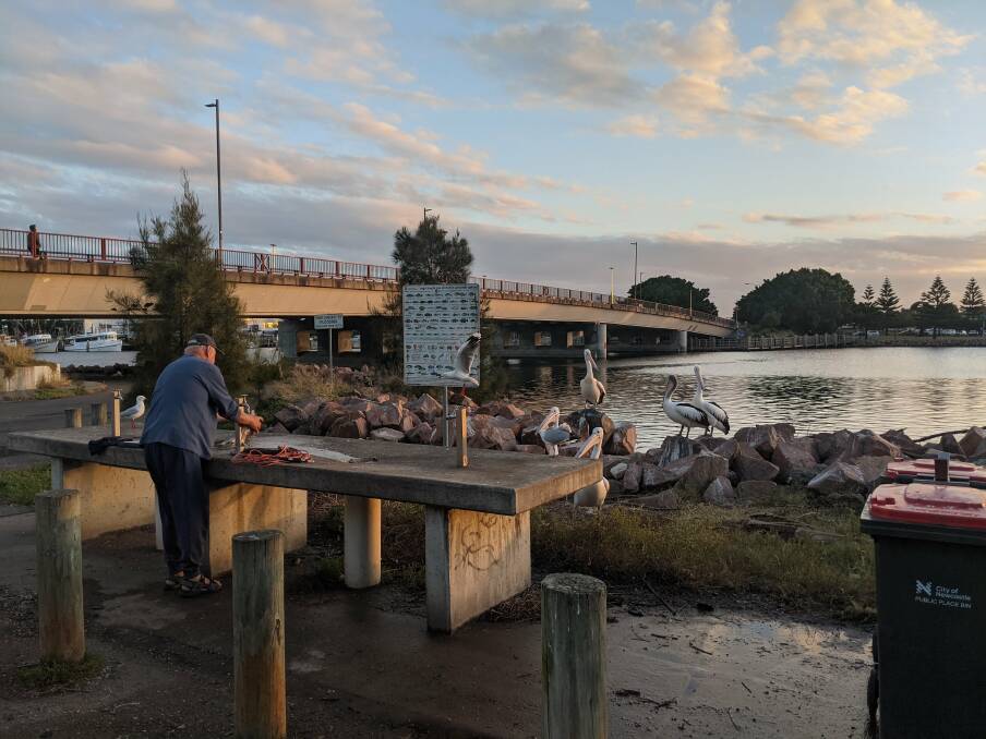 Living by the sea: Cleaning fish near the Cowper Street Bridge. Picture: Alex Morris