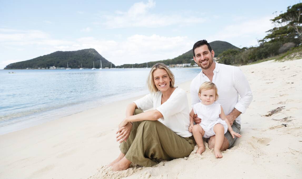 Project in paradise: Lauren and Michael Charge at Shoal Bay, with their youngest child, Claudia.