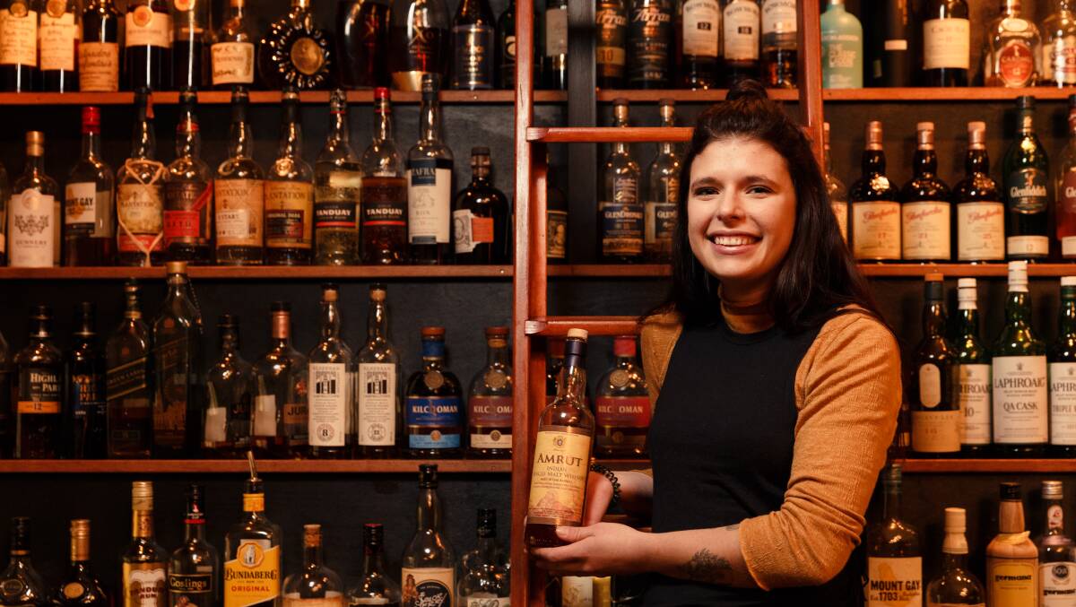 Taste of things to come: Babylon bar tender Abbie Semit holding an Amrut Indian Single Malt whiskey. Picture: Max Mason-Hubers