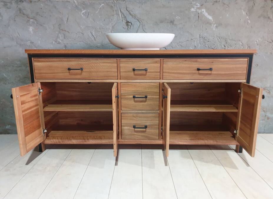 A Round 2 Timbers vanity with inset steel spotted gum four door five drawer.