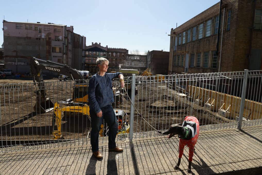 Space in Time: Keri Glastonbury, with her dog, Tilly, near the demolished David Jones site in Newcastle East. Her new book of hipster poetry, Newcastle Sonnets, was launched this week. Picture: Jonathan Carroll