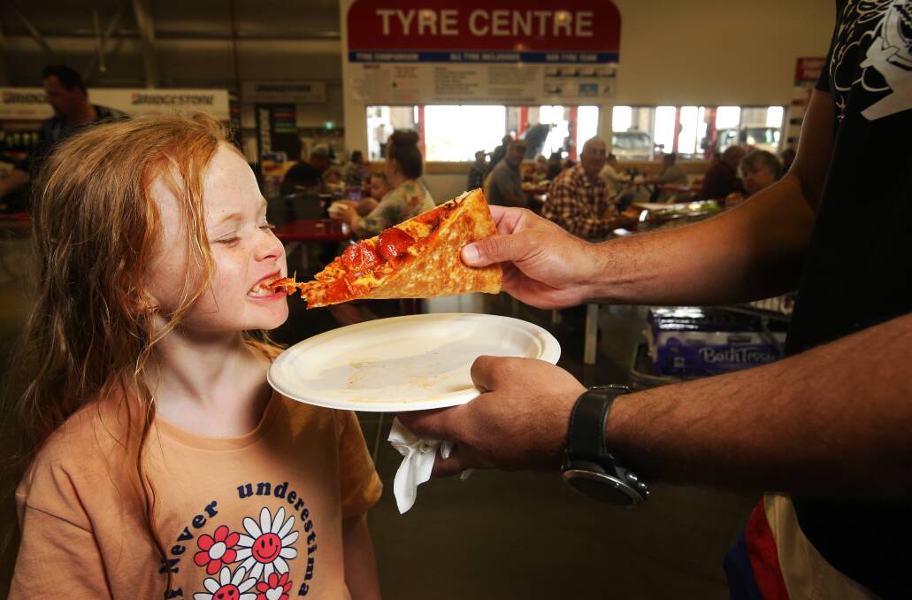 Charlotte Nymoen, 7, taking a bite out of a slice pizza from the food section at Costco. Picture by Simone De Peak