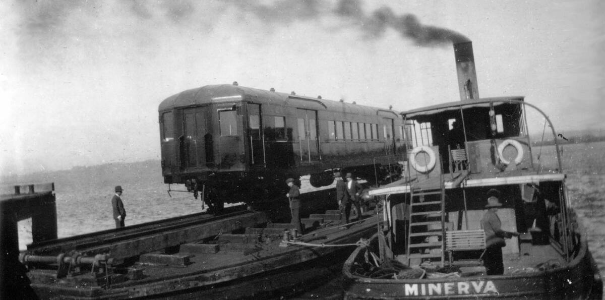 JOURNEY: A new electric rail carriage travels across the harbour from Walsh Island on a barge propelled by steam tug SS Minerva. Picture: ARHS/NSW Rail Resource Centre
