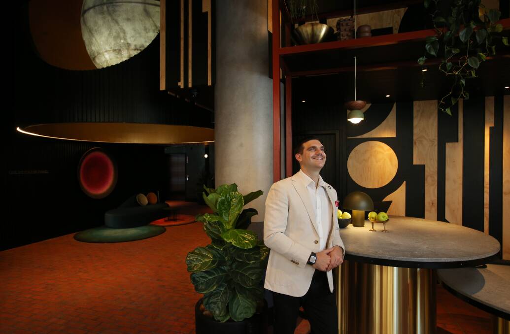 Ready for business: QT Newcastle general manager Michael Stamboulidis at the check-in desk of the new hotel which opens for business on Thursday. The Rooftop bar and ground floor Jana restaurant and cafe welcome locals, too. Picture: Simone De Peak