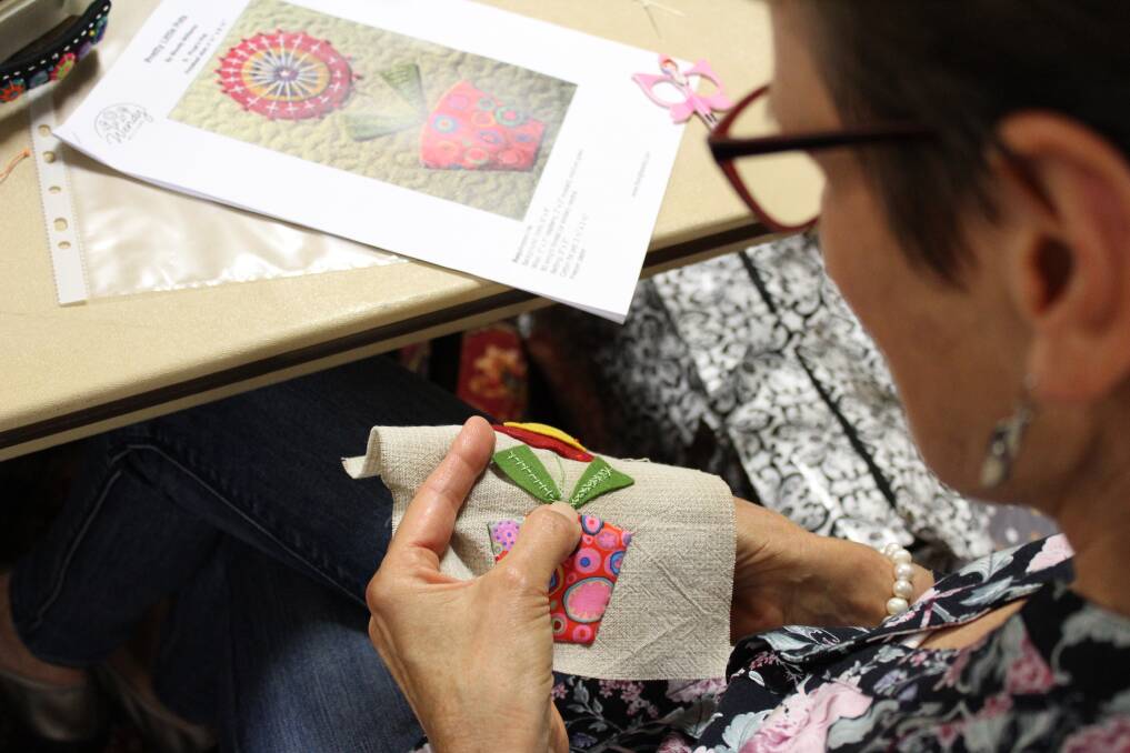 Ingrid Kennewell hand stitching at the quilters' gathering.
