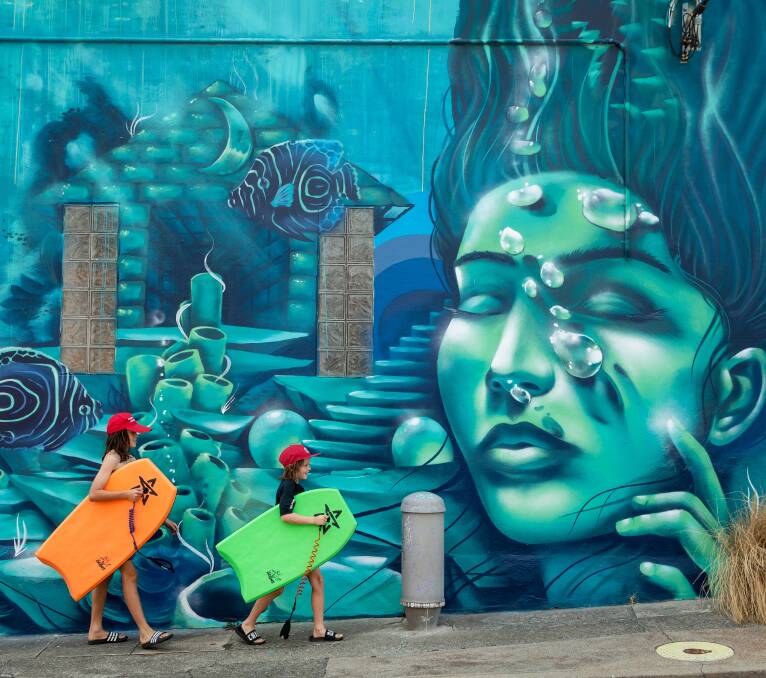 Uber cool: Sebastian and Elliott Thomas of Tighes Hill walking past Jordan Lucky's mural on Union Street. Picture: Marina Neil