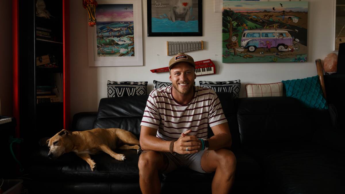 Classic on his mind: Mitch Revs at home in Merewether with his dog, Abby, who always features in his artwork. Picture: Max Mason-Hubers