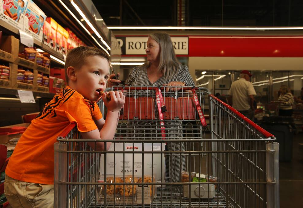 Eric Taubman, 5, munches a Costco cookie while shopping with his grandmother Kim Kane and mum at Costco Lake Macquarie. Picture by Simone De Peak