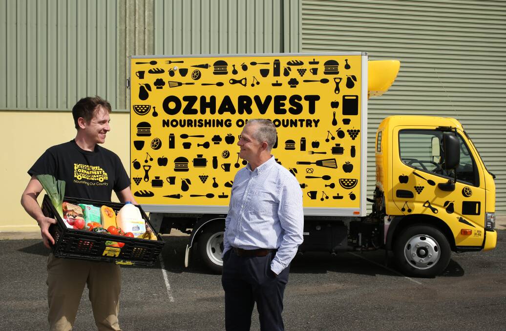 HELPING HANDS: Andrew Turner, of OzHarvest Newcastle, and Hennie du Plooy, of Port Waratah Coal Services. Picture: Simone De Peak