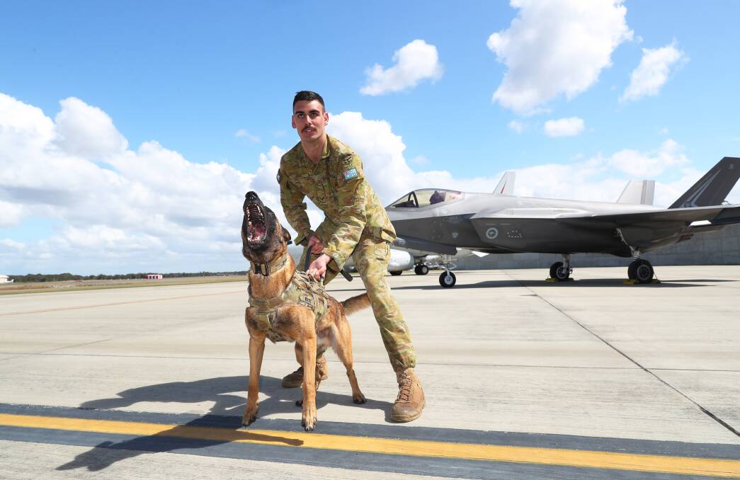 Leading aircraftman Jordan Dodd with military working dog Effi at RAAF Williamtown. The Newcastle Williamtown Air Show 2023 is on this weekend. Picture by Peter Lorimer