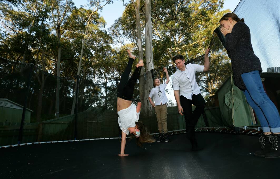 GIRL POWER: Thalia Standley does a one-handed cartwheel as siblings Nathan, Jacob and Jessica cheer her on. Picture: Jonathan Carroll