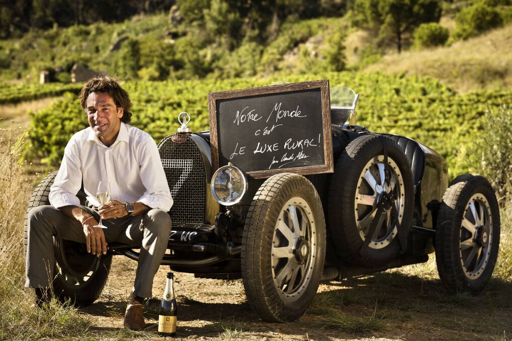 THE GOOD LIFE: Sipping a glass of white among his vines, Jean-Claude Mas relaxes alongside a Bugatti 27B from his vintage car collection.