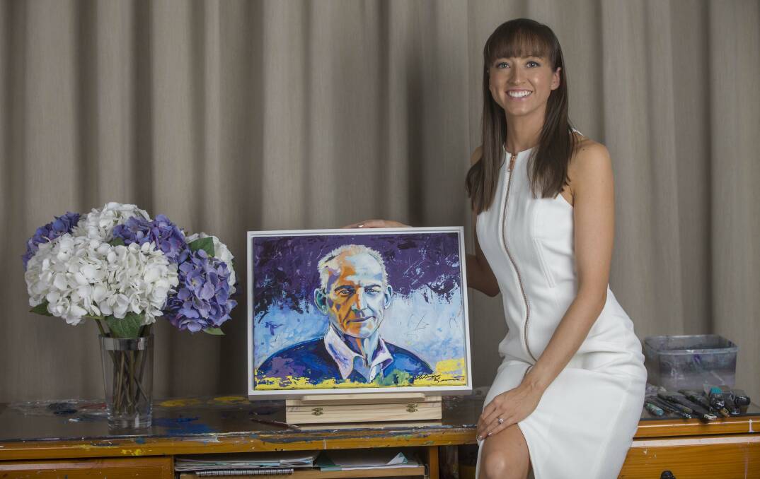 Artist Megan Adams with her portrait of former Knights coach Wayne Bennett. 