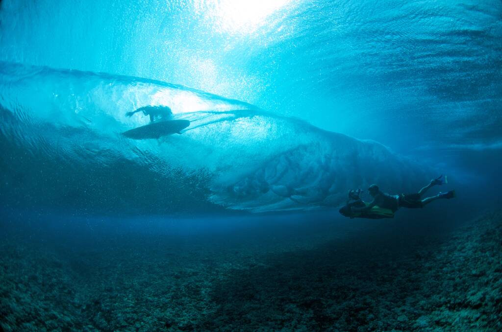 On Film: Jack McCoy filming Tahitian surfer Manoa Drollet at the island's most famous wave, Teahupoo. Picture: Tim McKenna 