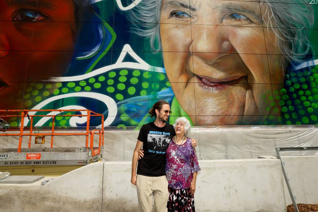 Artist Adnate (left) with a Newcastle mural he painted of Aunty Rose. 