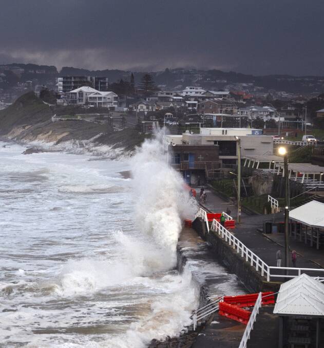 Hectic: Cooks Hill Surf Life Saving Club gets smashed in heavy seas at Bar Beach. Picture: David Diehm 